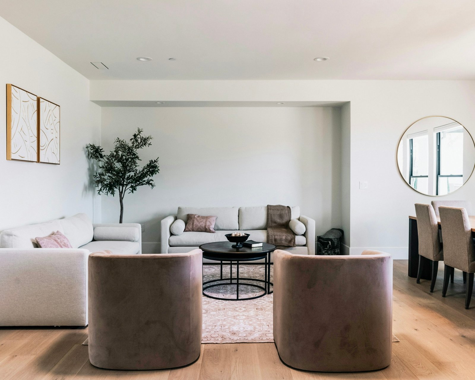 Neutral residential interior with sculptural armchairs and natural timber flooring